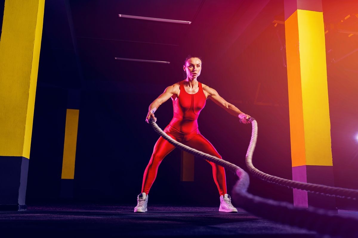 Fitness woman using training ropes for exercise at gym. Athlete working out with battle ropes at gym. Fitness woman using training ropes for exercise at gym. Athlete working out with battle ropes at gym.